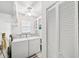 Bright laundry room with washer, dryer, shelving, and white cabinetry for convenient storage at 11514 Sun Rd, Dade City, FL 33525