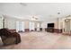 Bright living room features carpet, ceiling fan, and a large window for natural light at 11514 Sun Rd, Dade City, FL 33525