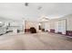 Open living room leading to the kitchen with carpet and large windows for natural light at 11514 Sun Rd, Dade City, FL 33525