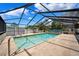 Outdoor pool inside screened enclosure with spacious patio area for relaxation and recreation at 11514 Sun Rd, Dade City, FL 33525