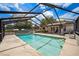Outdoor pool inside screened enclosure with spacious patio area, furniture, and access to backyard at 11514 Sun Rd, Dade City, FL 33525