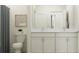 Modern bathroom featuring double sinks, white cabinets, and a stylish framed art piece and light blue curtain at 11546 E 71St Ter, Palmetto, FL 34221