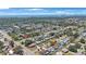Expansive aerial view of a neighborhood with tree-lined streets and distant ocean views under a bright, partly cloudy sky at 11619 80Th Ave, Seminole, FL 33772
