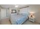 The spacious bedroom has a white dresser, side table and ceiling fan at 11619 80Th Ave, Seminole, FL 33772