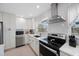 Bright kitchen features stainless steel appliances, black oven, and white cabinets at 11619 80Th Ave, Seminole, FL 33772