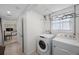 This laundry room features a washer and dryer, hanging rack, and a window for natural light at 11619 80Th Ave, Seminole, FL 33772