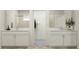 Modern bathroom featuring dual vanities with white cabinets and marble countertops with a connecting walk-in closet at 11744 E 71St Ter, Palmetto, FL 34221