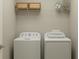 Functional laundry room equipped with a washer, dryer, and storage shelving for efficient organization at 11744 E 71St Ter, Palmetto, FL 34221