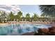 Inviting community pool with lounge chairs and cabanas surrounded by lush landscaping and palm trees at 11744 E 71St Ter, Palmetto, FL 34221