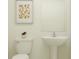 Clean, minimalist bathroom with a pedestal sink and framed artwork at 11848 Blue Diamond Trl, Parrish, FL 34219