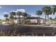 Inviting community clubhouse featuring a manicured lawn, palm trees, and convenient parking at 11848 Blue Diamond Trl, Parrish, FL 34219