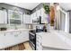 Galley kitchen features white cabinets, updated appliances, and tiled backsplash at 12323 Country White Cir, Tampa, FL 33635