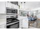 Open kitchen features white cabinets and stainless steel appliances, flowing into the living area at 12323 Country White Cir, Tampa, FL 33635