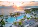 Aerial sunset view of a luxury resort featuring large pools, palm trees, and modern architecture by the waterfront at 128 Torrington St, Port Charlotte, FL 33954