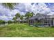 Lush backyard features a screened pool and a serene lake view at 128 Torrington St, Port Charlotte, FL 33954