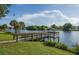 Wooden fishing pier on a serene lake surrounded by lush greenery and palm trees under a beautiful blue sky with white clouds at 128 Torrington St, Port Charlotte, FL 33954