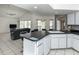 Open concept kitchen features a breakfast bar, white cabinetry, and views into the living room at 128 Torrington St, Port Charlotte, FL 33954