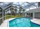 Relaxing pool area surrounded by lush palms in screened lanai at 128 Torrington St, Port Charlotte, FL 33954