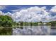 Scenic water view homes are beautifully reflected in the water, beneath fluffy white clouds at 128 Torrington St, Port Charlotte, FL 33954