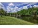 Scenic view of the calm water with green grass on the bank on a sunny day at 128 Torrington St, Port Charlotte, FL 33954
