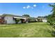 Expansive backyard featuring lush green lawn and mature landscaping, creating a private outdoor space at 14542 Anchorage Cir, Seminole, FL 33776