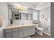 Well-lit bathroom featuring a large mirror, white vanity, and a separate toilet area, exuding a clean ambiance at 14542 Anchorage Cir, Seminole, FL 33776
