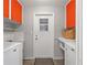 Functional laundry room with modern appliances, bright orange cabinets, and storage space, maximizing efficiency at 14542 Anchorage Cir, Seminole, FL 33776