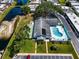 Aerial view of community featuring a pool, tennis courts, and manicured grounds at 149 Sky Loch Dr E, Dunedin, FL 34698