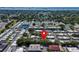 Aerial view of residential community, lush landscape, and red pin indicating property location at 149 Sky Loch Dr E, Dunedin, FL 34698