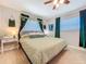 Cozy bedroom featuring a ceiling fan, decorative curtains, and an upholstered headboard at 149 Sky Loch Dr E, Dunedin, FL 34698