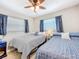 Bedroom featuring 2 beds, neutral carpet, ceiling fan, and a window at 149 Sky Loch Dr E, Dunedin, FL 34698