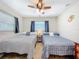 Bedroom featuring 2 beds, neutral carpet, ceiling fan, and a window at 149 Sky Loch Dr E, Dunedin, FL 34698