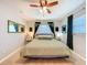 Bedroom featuring neutral carpet, ceiling fan, decorative mirror, and accent furniture at 149 Sky Loch Dr E, Dunedin, FL 34698
