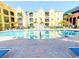 Inviting community pool surrounded by colorful buildings, swaying palm trees, and comfortable lounge seating at 1910 E Palm Ave # 10209, Tampa, FL 33605