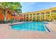 Large pool area surrounded by lounge chairs, lush trees and community buildings, perfect for relaxation at 1910 E Palm Ave # 10209, Tampa, FL 33605