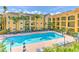 Exterior view of sparkling pool with blue lounge chairs and yellow buildings in the background at 1910 E Palm Ave # 10209, Tampa, FL 33605