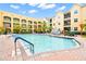 Well-maintained community pool area featuring lounge chairs, lush trees, and inviting buildings with balconies at 1910 E Palm Ave # 10209, Tampa, FL 33605