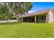Large backyard showcasing lush lawn, mature trees, and a screened lanai, offering privacy and space at 19207 Autumn Woods Ave, Tampa, FL 33647