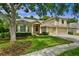 Charming two-story home with a well-manicured lawn, mature trees, and a convenient three-car garage at 19207 Autumn Woods Ave, Tampa, FL 33647