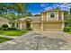 Inviting two-story home boasts a lush lawn, mature trees, and a spacious driveway leading to a three-car garage at 19207 Autumn Woods Ave, Tampa, FL 33647