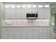 Kitchen with stainless steel microwave, tiled backsplash, granite countertops and white cabinetry at 19207 Autumn Woods Ave, Tampa, FL 33647