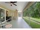 Relaxing screened lanai with ceiling fans, outdoor seating and grill, offering serene views of the private backyard at 19207 Autumn Woods Ave, Tampa, FL 33647