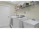 Well-organized laundry room equipped with modern washer, dryer, sink, and ample shelving for storage at 19207 Autumn Woods Ave, Tampa, FL 33647