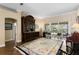Spacious living room boasting an ornate cabinet, hardwood floors, and seamless access to adjacent rooms at 19207 Autumn Woods Ave, Tampa, FL 33647