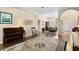 Bright and airy living room featuring a piano, hardwood floors, and seamless access to adjacent rooms at 19207 Autumn Woods Ave, Tampa, FL 33647