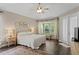 Spacious main bedroom with a ceiling fan, hardwood floors, a large window and private outdoor access at 19207 Autumn Woods Ave, Tampa, FL 33647