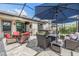 Screened-in back patio features comfortable furniture, an umbrella, and an outdoor TV at 19400 Roseate Dr, Lutz, FL 33558