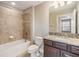 Bathroom featuring a shower-tub combo, tile flooring, and granite countertops at 19400 Roseate Dr, Lutz, FL 33558