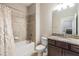 Bathroom featuring shower over tub, granite topped vanity and commode, with laundry room access at 19400 Roseate Dr, Lutz, FL 33558