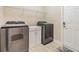 Laundry room with stainless steel washer and dryer on light tile floor at 19400 Roseate Dr, Lutz, FL 33558